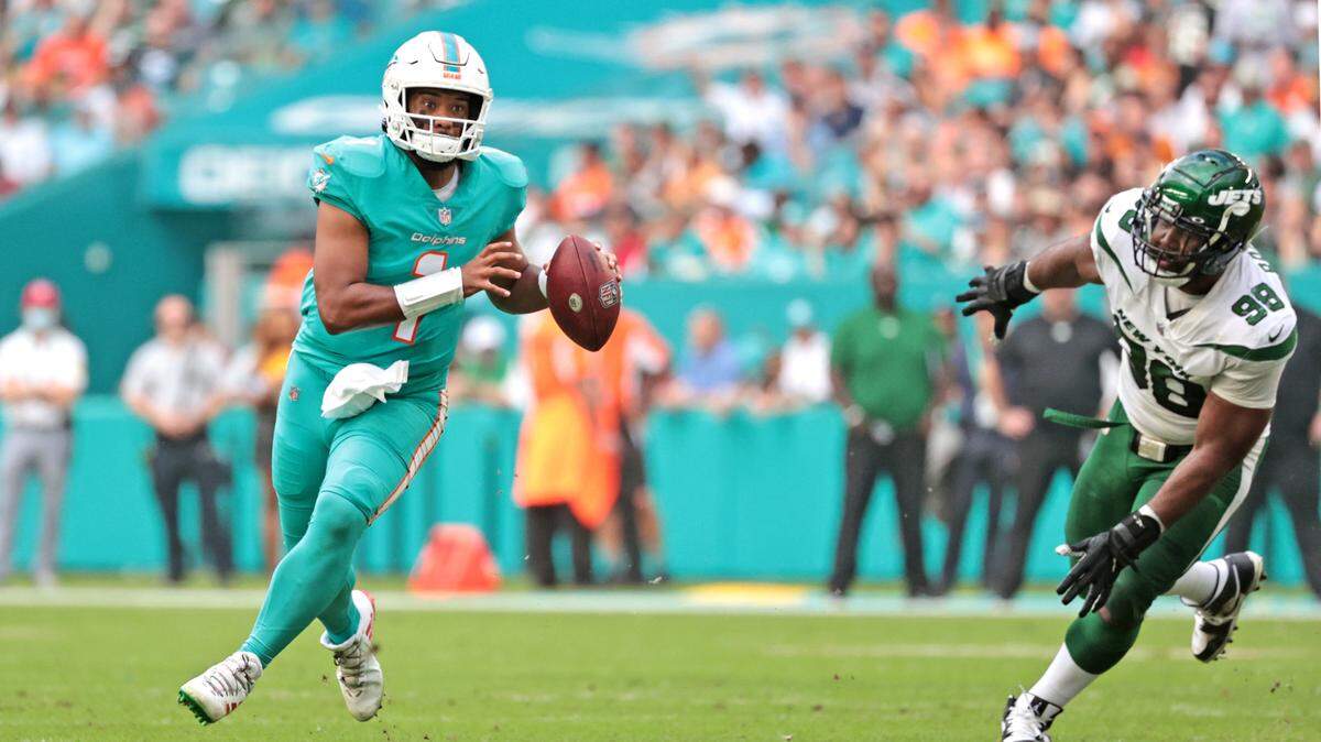 Miami Dolphins quarterback Tua Tagovailoa (1) looks to pass as New York Jets defensive tackle Sheldon Rankins (98) gives chase in the first half at Hard Rock Stadium in Miami Gardens on Sunday, December 19, 2021.
