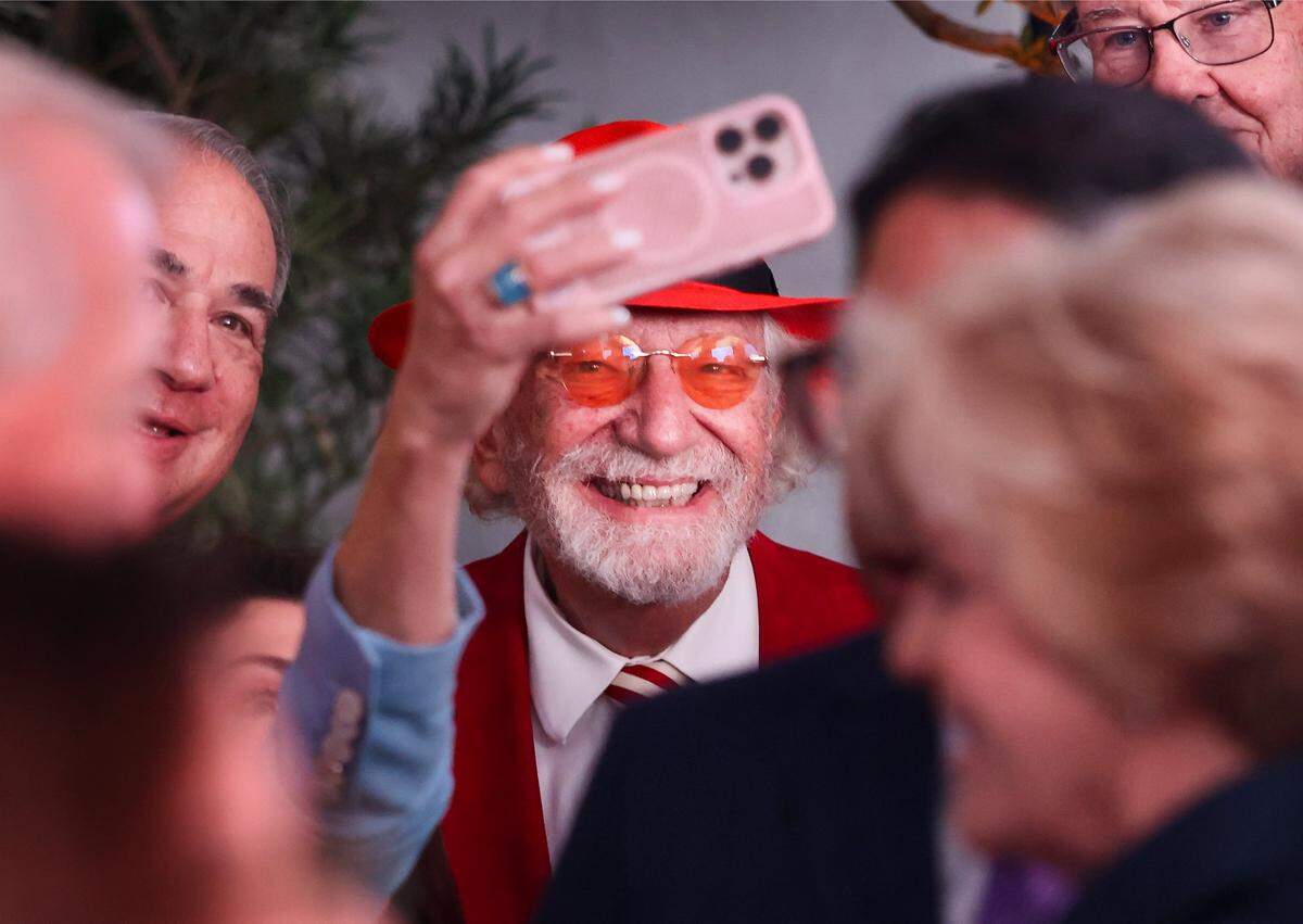 Dr. Herbert Wertheim, center, pauses for a selfie with admirers while greeting attendees during the celebration at Baptist Health marking his historic philanthropic gift and the naming of the Herbert Wertheim Cancer Institute. Baptist Health South Florida and the Baptist Health Foundation announced the largest single philanthropic gift in the organization's 66-year history from Dr. Herbert Wertheim during a celebration of the donation and Wertheim's upcoming birthday at Baptist Health in Kendall, Wednesday, May 20, 2026, in Miami, Florida. Attendees donned red hats-a signature of Dr. Wertheim-in tribute to his visionary philanthropy and in recognition of his lasting impact on the Baptist Health and FIU.