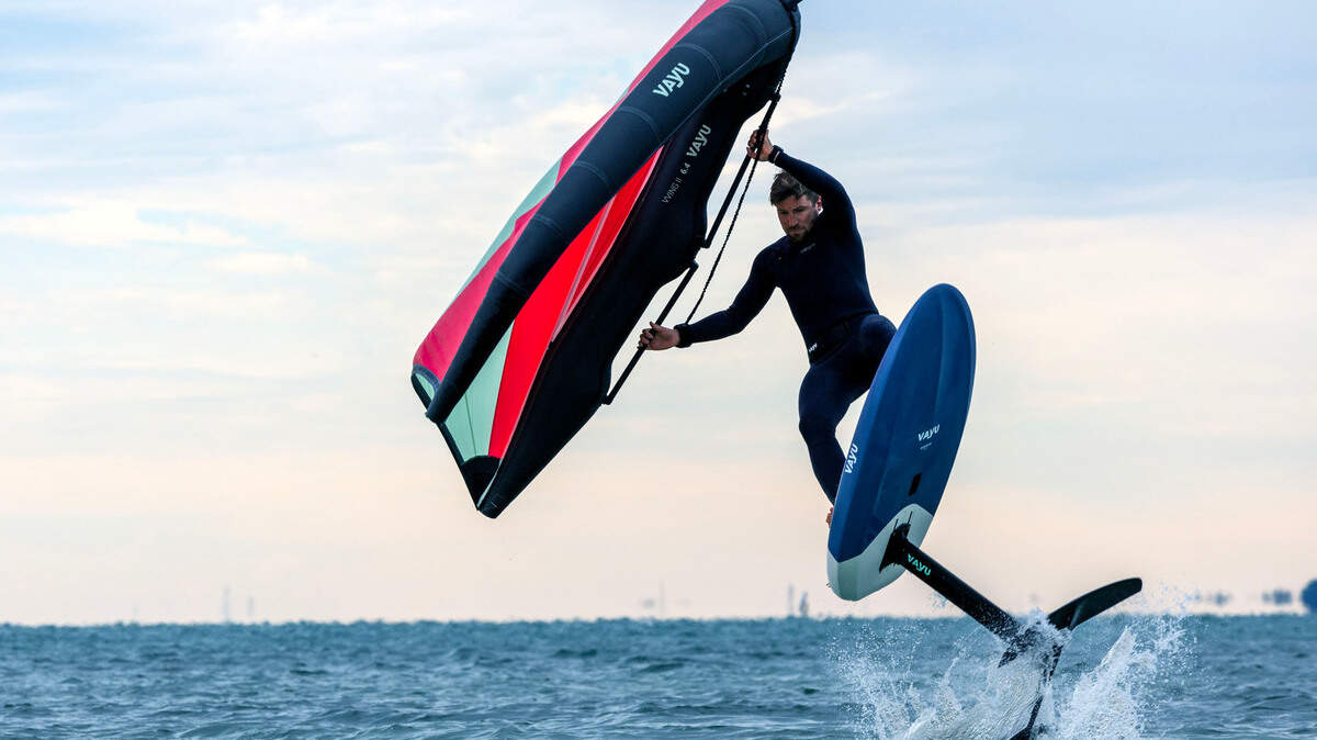 A winger-surfer comes to shore off Key Biscayne Dog Beach in Miami, Florida, on a chilly Dec. 24, 2022, when temperatures were in the upper 40s and low 50s. A week later, on New Year’s Eve Dec. 31, 2022, the weather forecast is different. Temperatures will be in the low 80s and could hit a record 84 degrees.