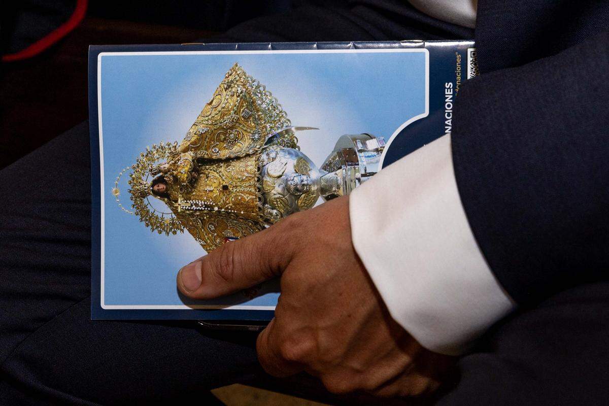 A congregant holds a program guide from during the annual celebration of the feast day of Cuba's patroness, Our Lady of Charity, at Ermita de la Caridad, also known as National Shrine of Our Lady of Charity, on Monday, September 8, 2025, in Coconut Grove, Fla.