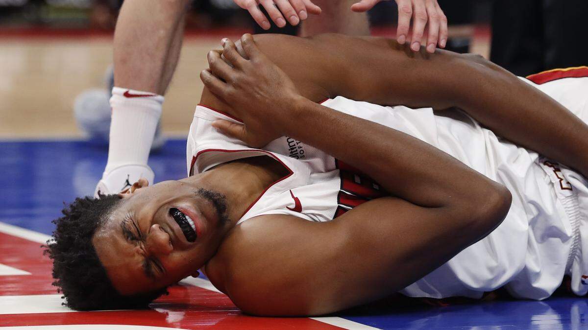 El centro del Heat Hassan Whiteide cae adolorido al golpearse el hombro tras sufrir una falta del centro de Detroit Zaza Pachulia este viernes en Detroit.