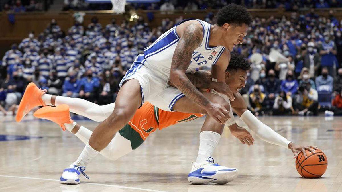 UM guard/forward Jordan Miller (in orange) battles Duke’s Paolo Banchero for a loose ball during the Hurricanes’ 76-74 road win over No. 2 Duke on Jan. 8, 2022.