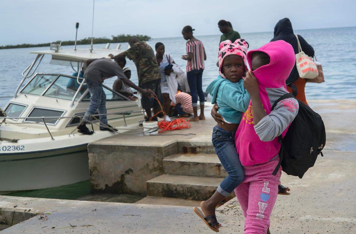 A woman carries a girl in her arms after being evacuated from a nearby Cay due to the danger of floods after arrive on a ship at the port before the arrival of Hurricane Dorian in Sweeting’s Cay, Grand Bahama, Bahamas, Saturday Aug. 31, 2019. (AP Photo / Ramon Espinosa)