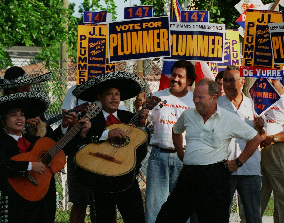 Miami City Commissioner J.L.Plummer enjoys the music of the Aguila Real Marichi as they inspire voters at the Eugenio Maria de Hostos community center in Wynwood in the 1990s.
