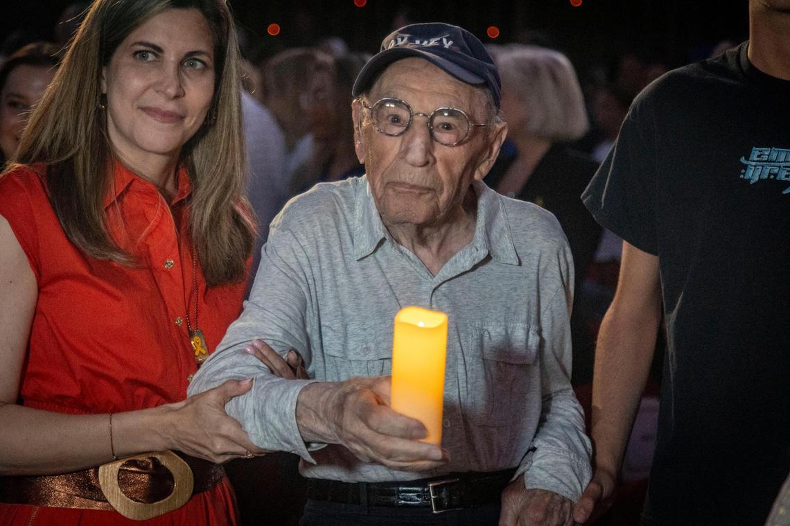 Miami Beach, FL, April 27, 2025 - Holocaust survivor Jack Waksal, center, carries a candle as he walks in a procession of Holocaust Survivors into a ceremony to Commemorate Yom HaShoah, Holocaust Remembrance Day at Temple Emanu-El in Miami Beach.