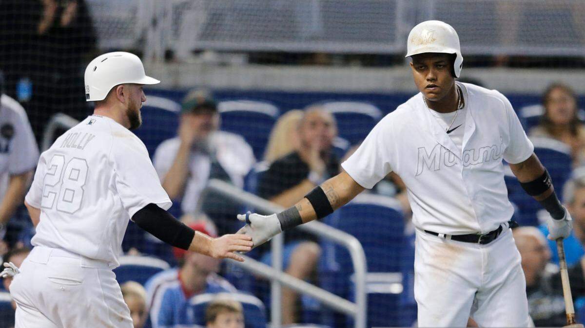 Miami Marlins catcher Bryan Holaday (28) celebrates with third baseman Starlin Castro after scoring a run in the sixth inning against the Philadelphia Phillies on Sunday, Aug. 25, 2019, at Marlins Park.