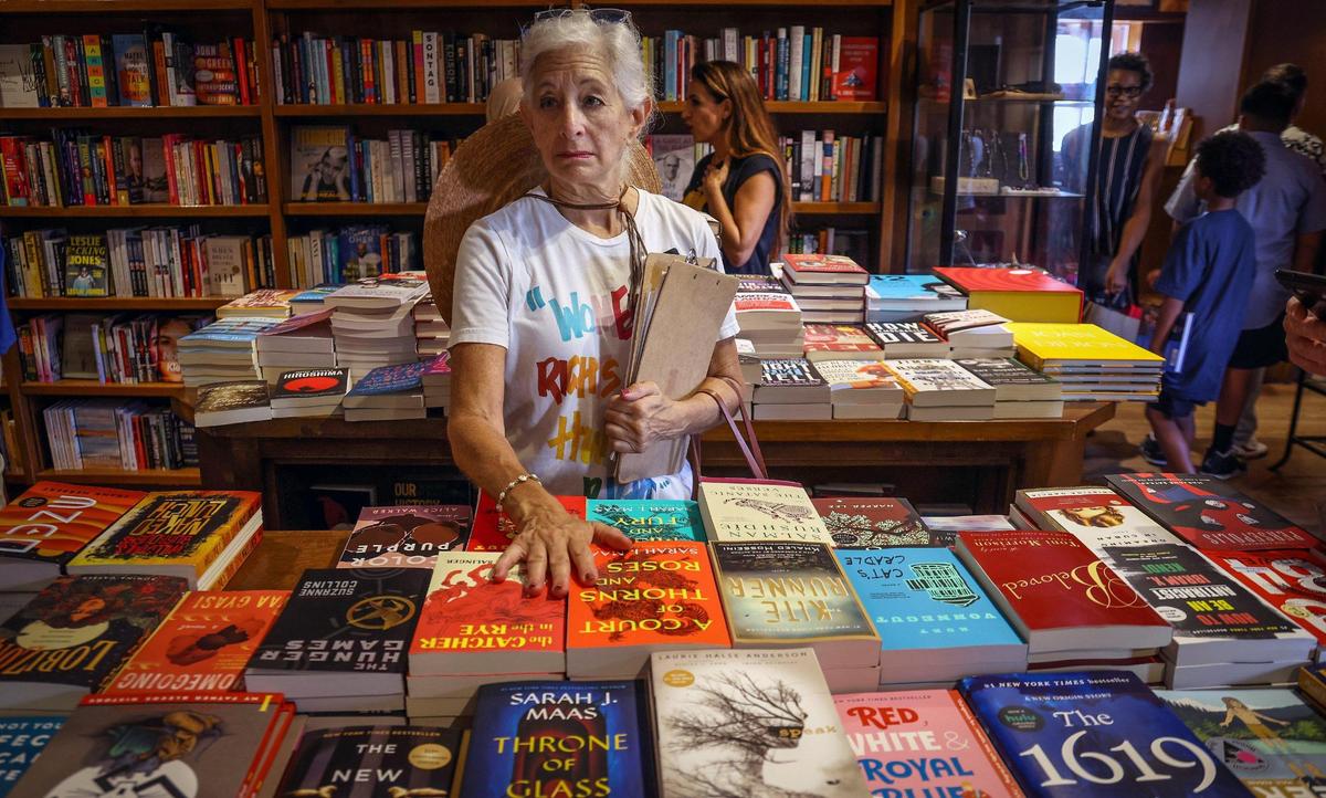 Retired social worker and Coral Gables resident Julie Samkoff is in shock as she reads the titles of some of the banned books displayed together during the “Walk for Freadom” kickoff event on Sunday, October 1, 2023 in Coral Gables, Florida. “It makes me fearful. I’ve read so many books that are banned in middle school and high school...many were given to me by my mother” says Samkoff. The march began at the Coral Gables Congregational United Church of Christ and ended at Books & Books.