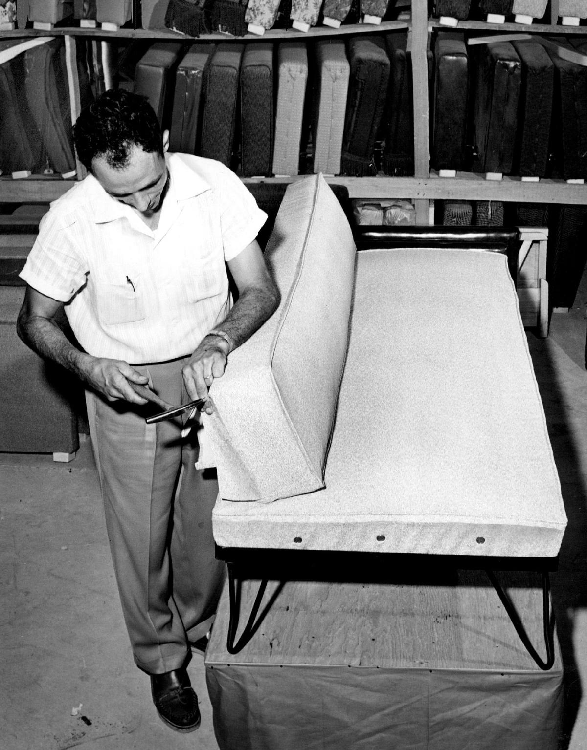 Richard De Maria of Dixie Bedding Co. in Hialeah tacks mildew-proof plastic to the back of a sofa. The factory, which was started in 1946, is being redeveloped as a music and arts venue by developer Avra Jain and partners.