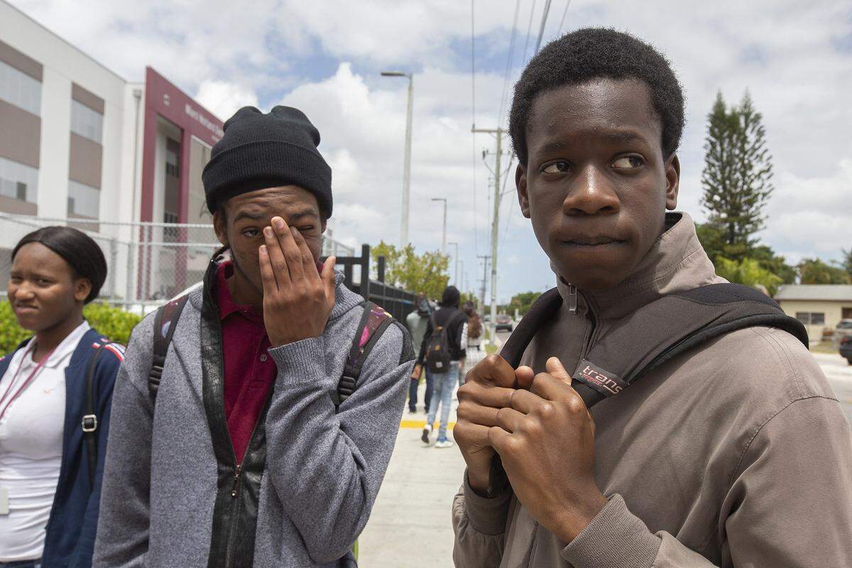 Otis Ridley, 15, and Nathaniel Douglas, 14, both freshmen at Miami Norland Senior High in Miami Gardens, talk after the confirmation of the murder of Kameela Russell, the school’s testing coordinator, at the school on Wednesday.