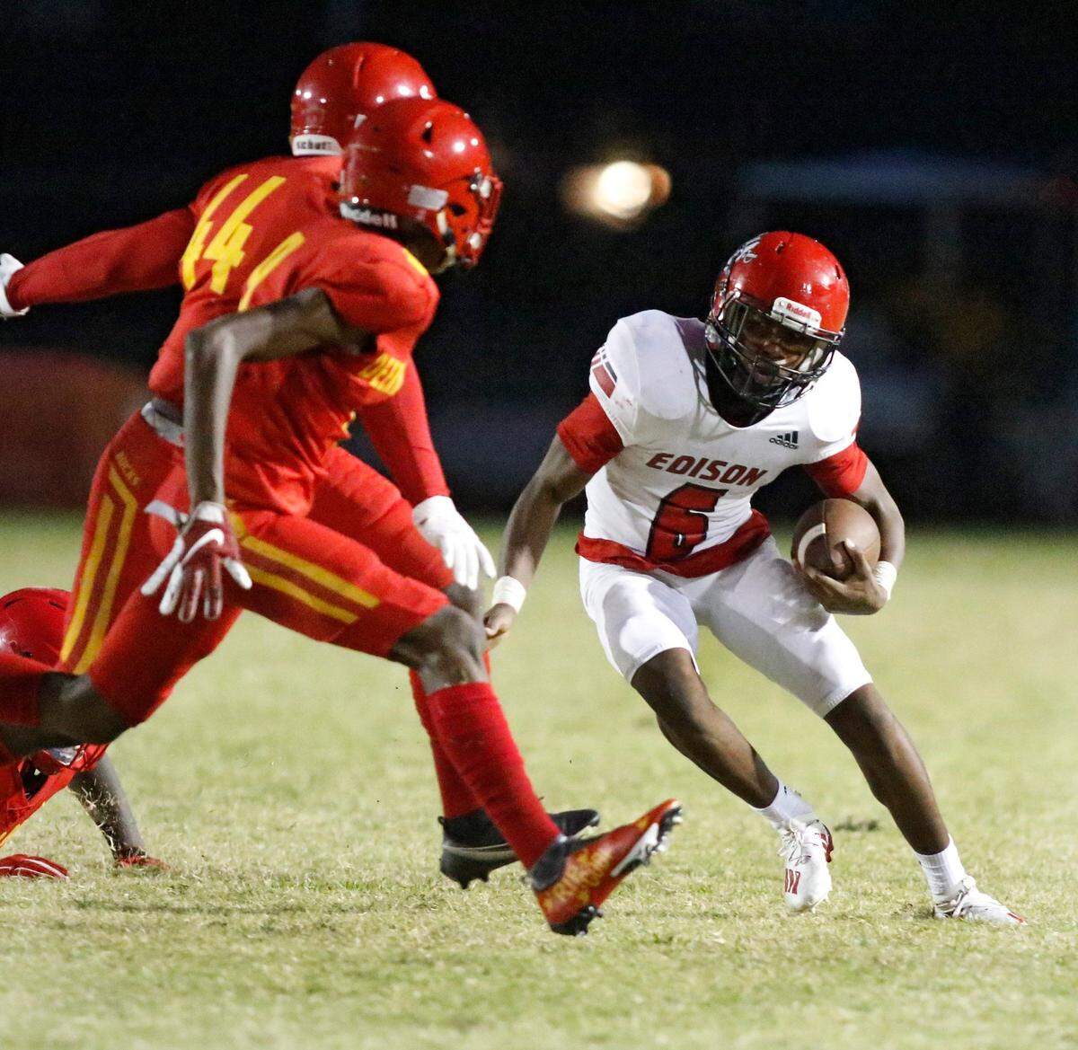 Miami Edison running back Gerald Modest (6) looks for the way to escape Deerfield Beach defenders during high school football opener on Friday, August 27, 2021 at Deerfield Beach HS in Deerfield Beach