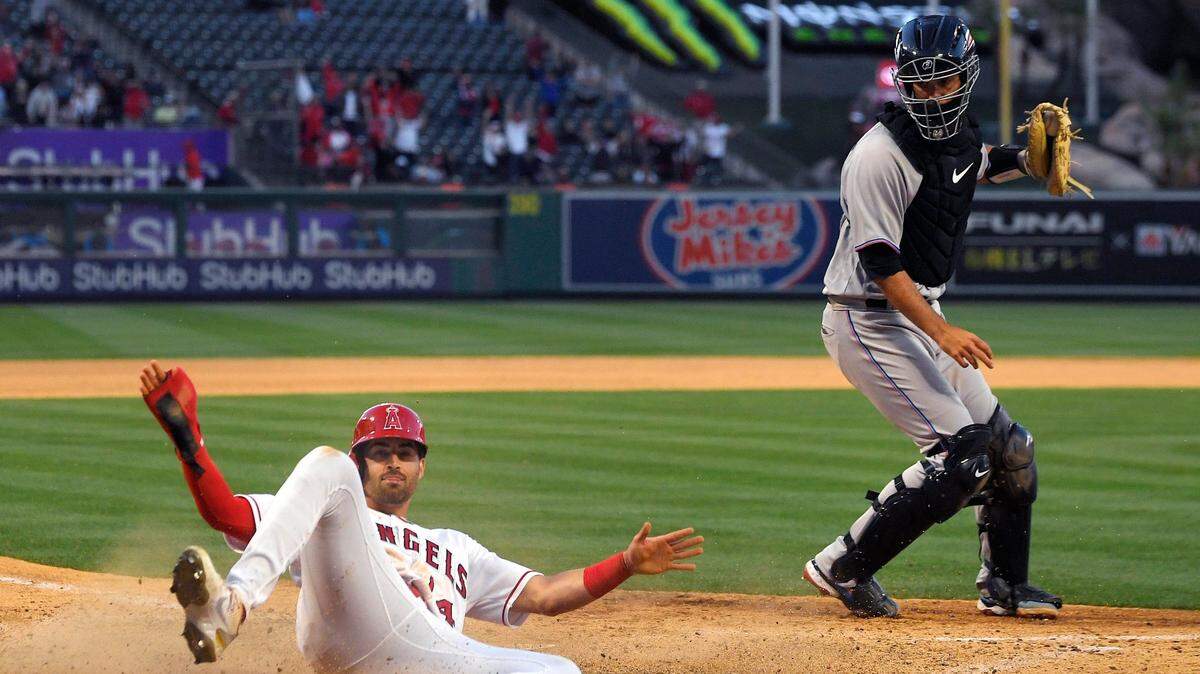 Los Angeles Angels’ Tyler Wade, left, scores on a Max Stassi walk off fielder’s choice as Miami Marlins catcher Jacob Stallings takes a late throw during the ninth inning of a baseball game Tuesday, April 12, 2022, in Anaheim, Calif. The Angels won 4-3.