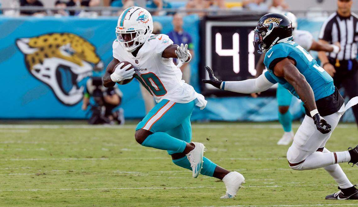Miami Dolphins wide receiver Tyreek Hill (10) the ball as Jacksonville Jaguars safety Andre Cisco (5) gives chase in the first quarter at EverBank in Jacksonville, Florida on Saturday, August 26, 2023.