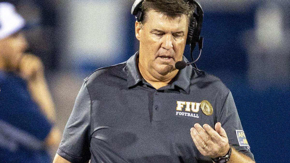 Florida International University Head Coach Mike MacIntyre flips a coin on the sidelines during the first quarter of an NCAA Conference USA football game against Bryant University at Riccardo Silva Stadium in Miami, Florida, on Thursday, September 1, 2022.