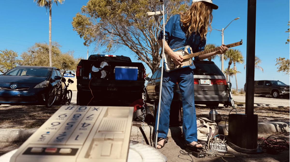 Jack Berry plays a one-string guitar he made out of a cereal box, a yardstick and discarded electric guitar parts. He sings into a fax machine receiver.