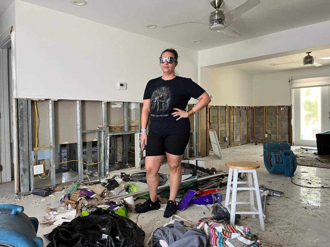 Renee Longini, a nurse anesthetist, stands in her Fort Lauderdale living room, which saw three feet of floodwater during the rainstorm. Longini said it could take four to six months to repair her home.