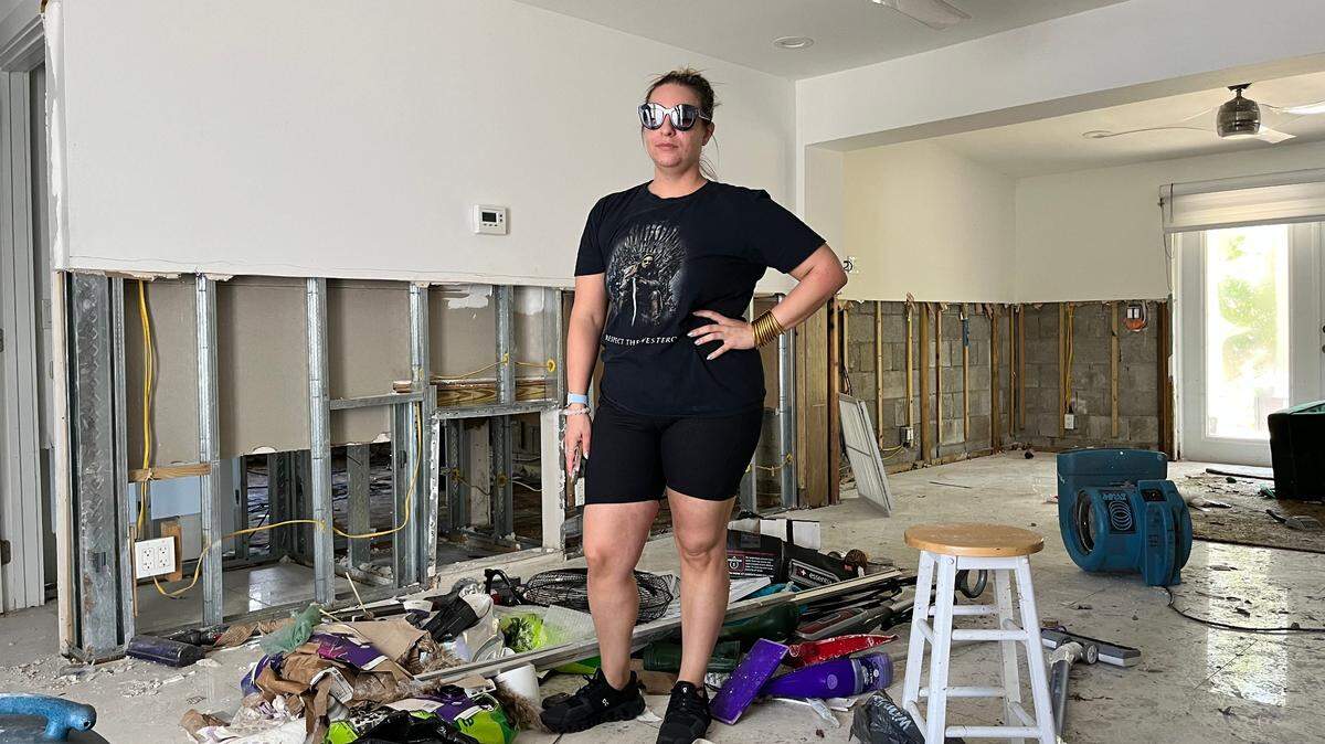 Renee Longini, a nurse anesthetist, stands in her Fort Lauderdale living room, which saw three feet of floodwater during the rainstorm. Longini said it could take four to six months to repair her home.
