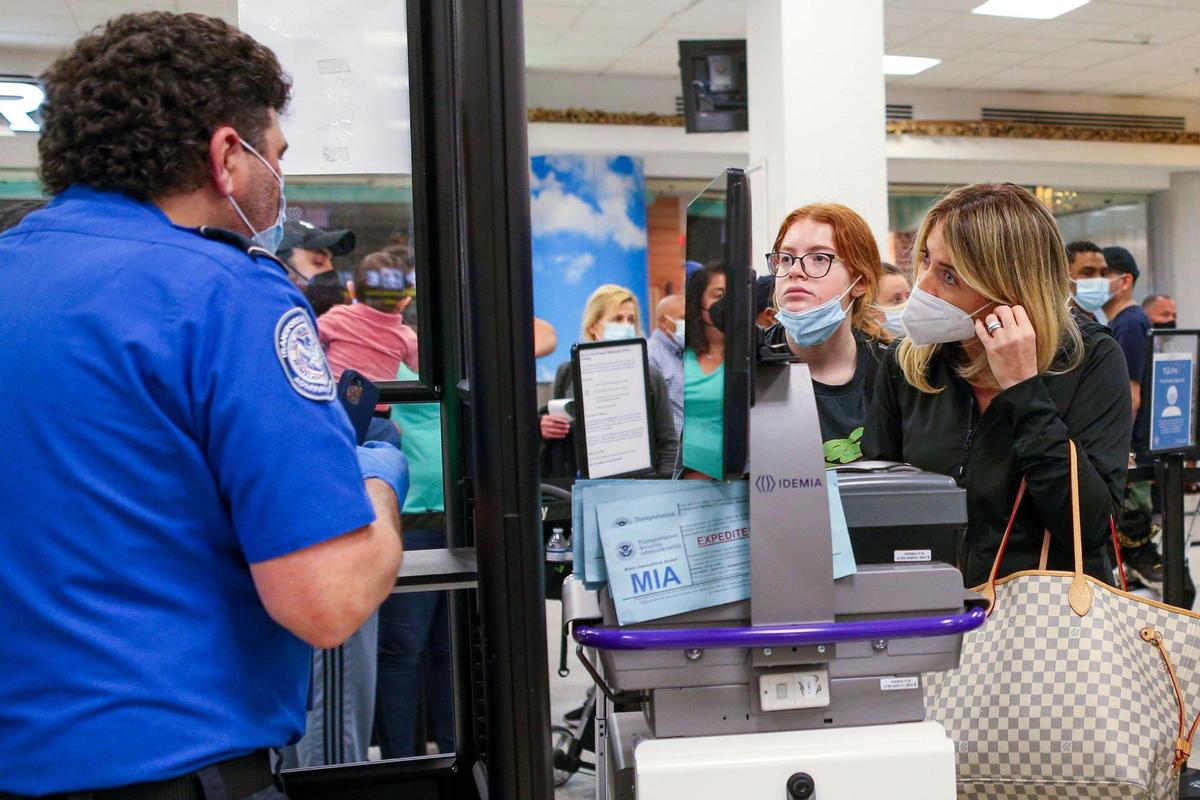 Travelers go through security at Miami International Airport in Miami, Florida, on Monday, November 22, 2021.