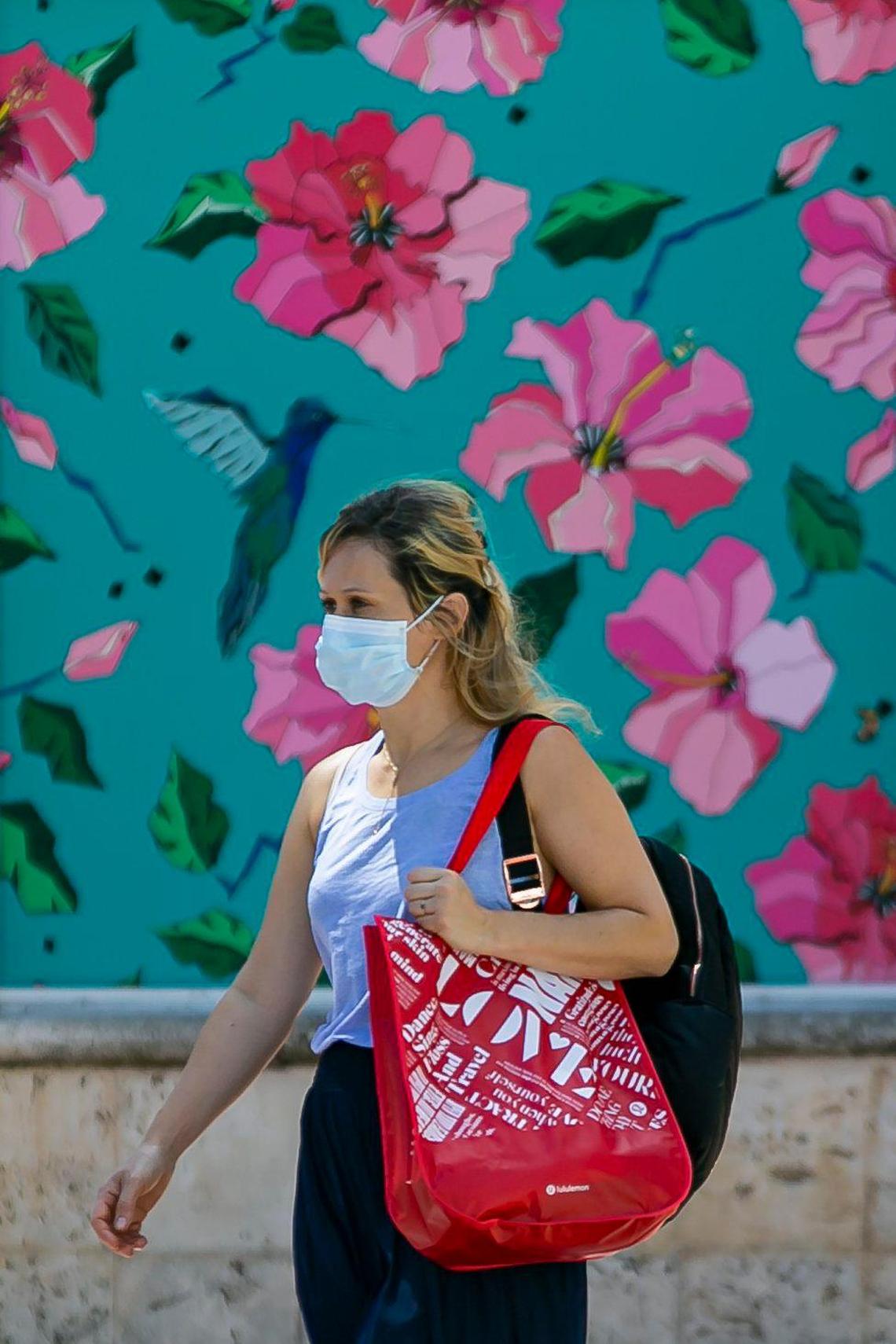 A woman walks down Lincoln Road in Miami Beach, Florida on Saturday, March 14, 2020.