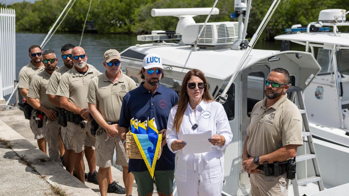 Melissa Fernandez and her husband, Andres Fernandez, present Fly High, Bird flags to members of the Miami-Dade Marine Patrol Unit at Black Point Park and Marina on Friday, Aug. 30, 2024, in Homestead, Fla. The Fernandezes, who started the Lucy Fernandez Foundation after their 17-year-old daughter Luciana was killed in a boat crash two years ago in Biscayne Bay, hope to raise awareness about boat safety with the flags that will hang on various Miami-Dade Police vessels.