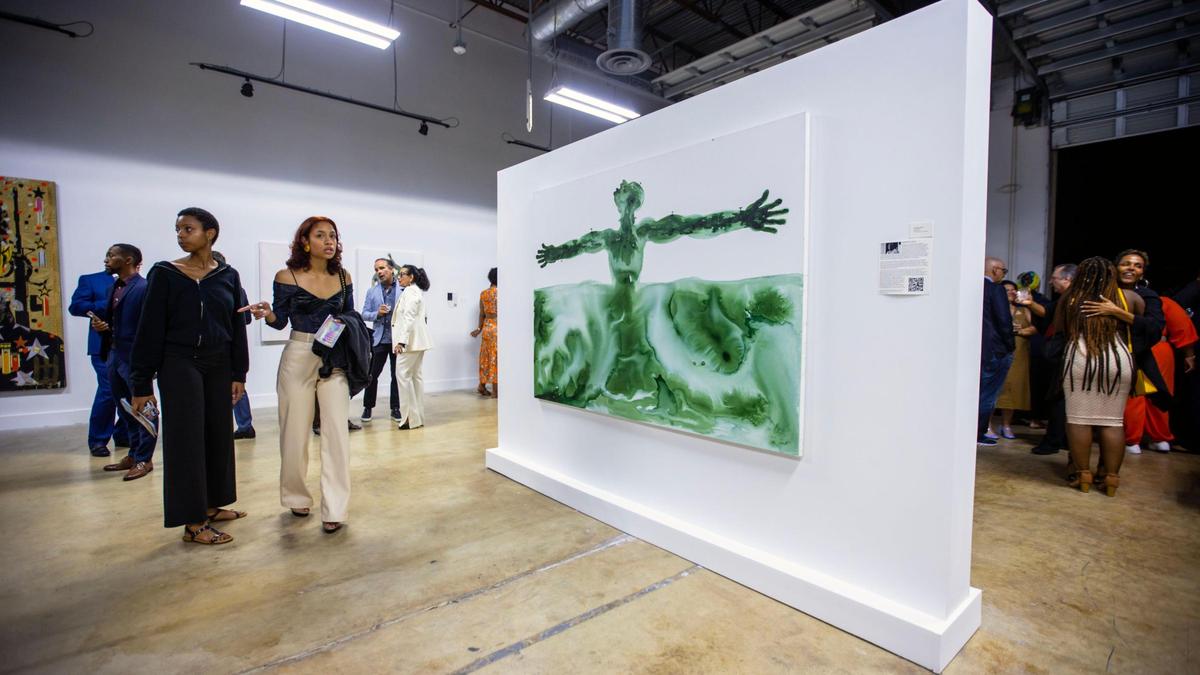 People socialize and view artwork during the Preview for The Art of Transformation event at The ARC and Logan Building in Opa-locka, Florida, on Wednesday, November 30, 2022. The event is a five-day, three-block Mecca of African and Haitian art fair coinciding with Art Basel Miami Beach 2022 and just one of over 40 ‘exhibits’ part of 2022 Art of Black Miami.