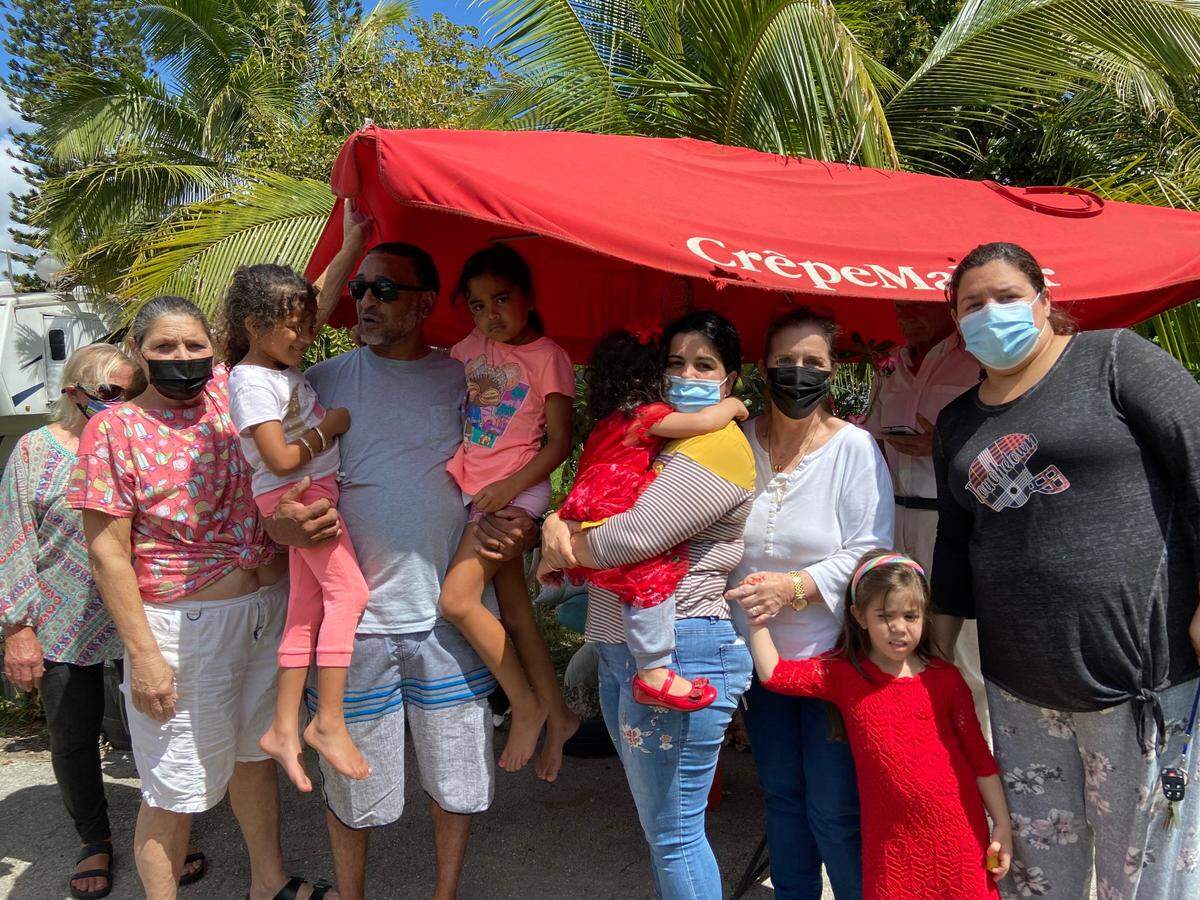 Residents of Florida City Campgrounds and RV Park gather beneath an umbrella Friday, March 12, 2021. Florida City, which owns the campground, told residents it has been sold to a private developer and they must leave by Wednesday, March 17, 2021.