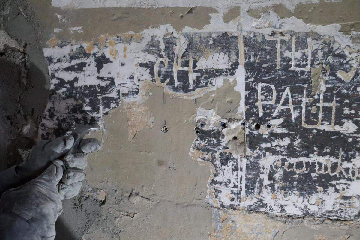 When researchers peeled off the layers of plaster and paint, they found names written by workers a century ago.