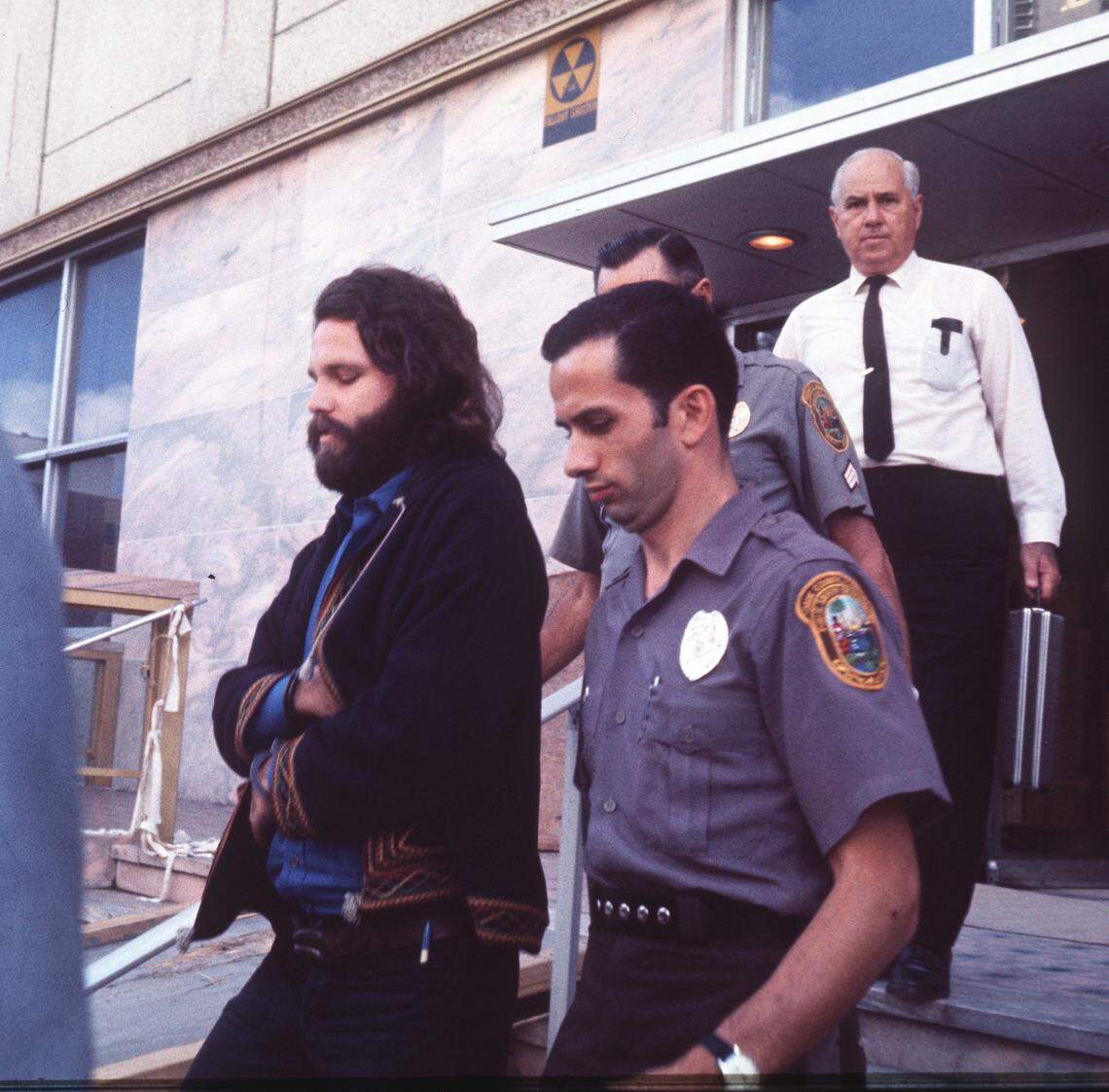 Jim Morrison being led to Miami-Dade County Jail in in September 1970.