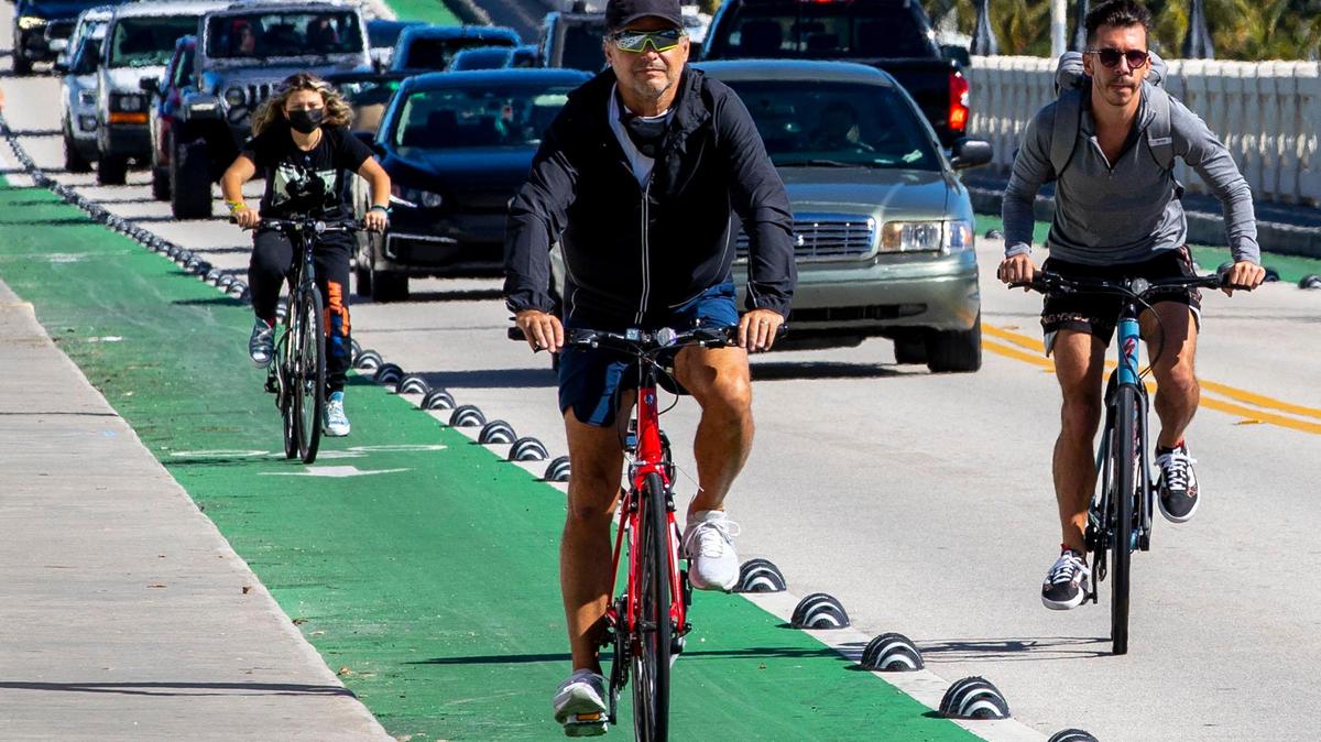 Un hombre en bicicleta intenta adelantar a otro ciclista en el carril para bicicletas en el Viaducto Venetian.