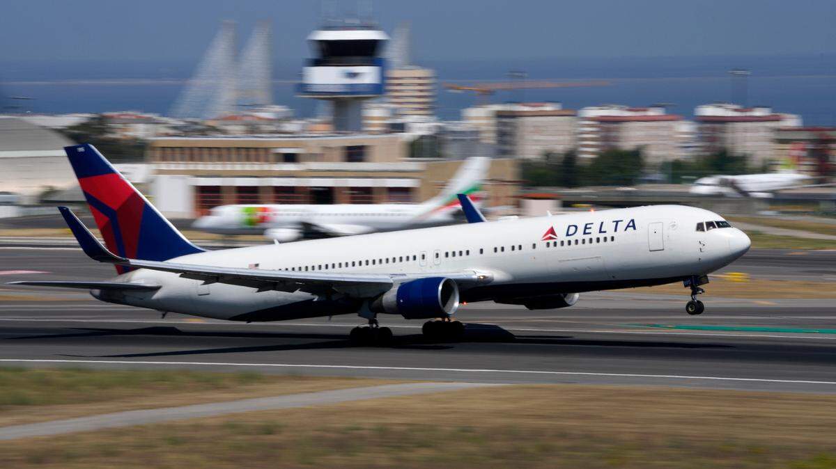 A former Delta Air Lines flight attendant is suing the company and says she was fired for a Facebook post showing former President Donald Trump with a KKK hood.