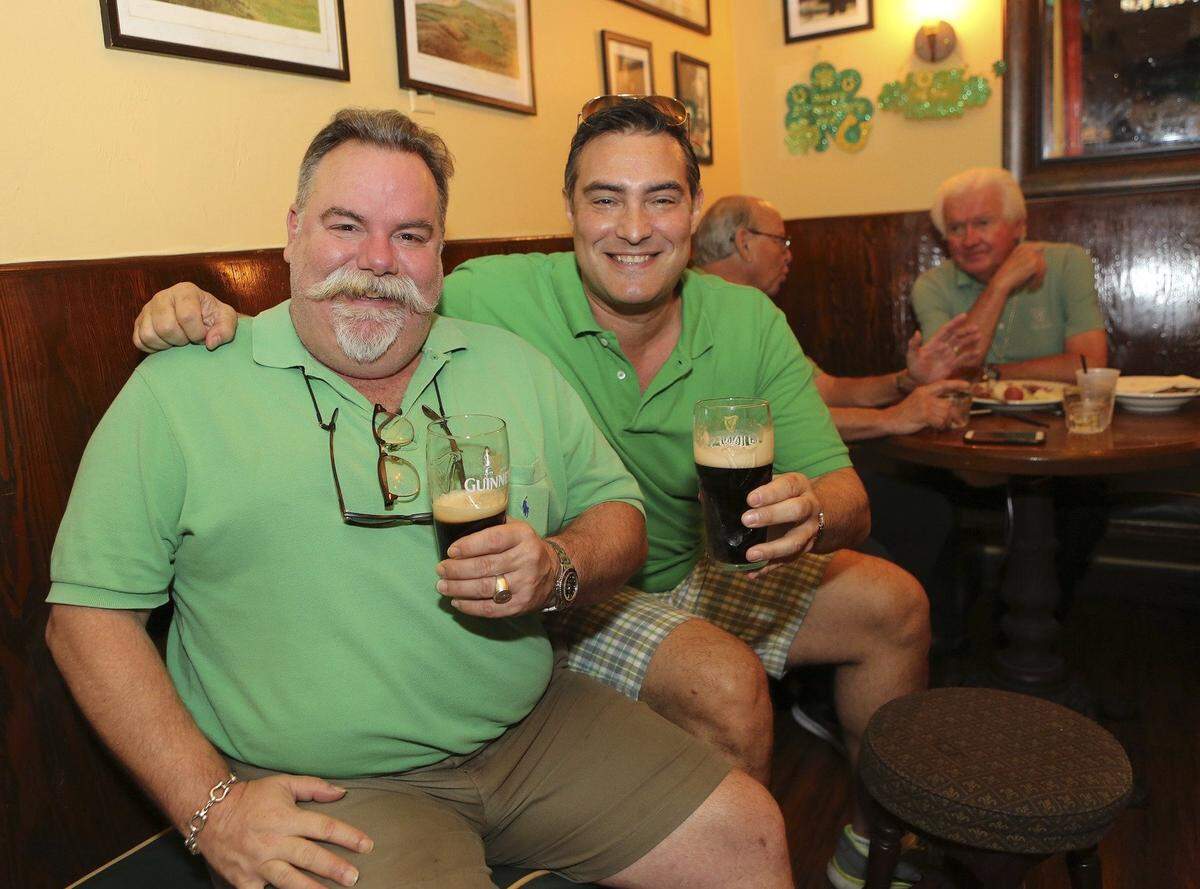 Friends Julio Galletti, left, and Danny Palacio, both of Coral Gables, relax with glasses of Guinness stout during the annual St. Patrick’s Day party at John Martin’s Irish Pub & Restaurant, 253 Miracle Mile in Coral Gables. The pub is celebrating its 30th anniversary.