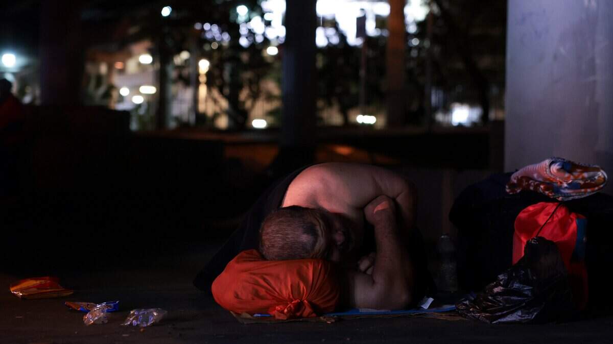 A man experiencing homelessness sleeps under the Interstate 95 overpass during the Homeless Trust's biannual Homeless Census in downtown Miami on Thursday, Jan. 22, 2026.