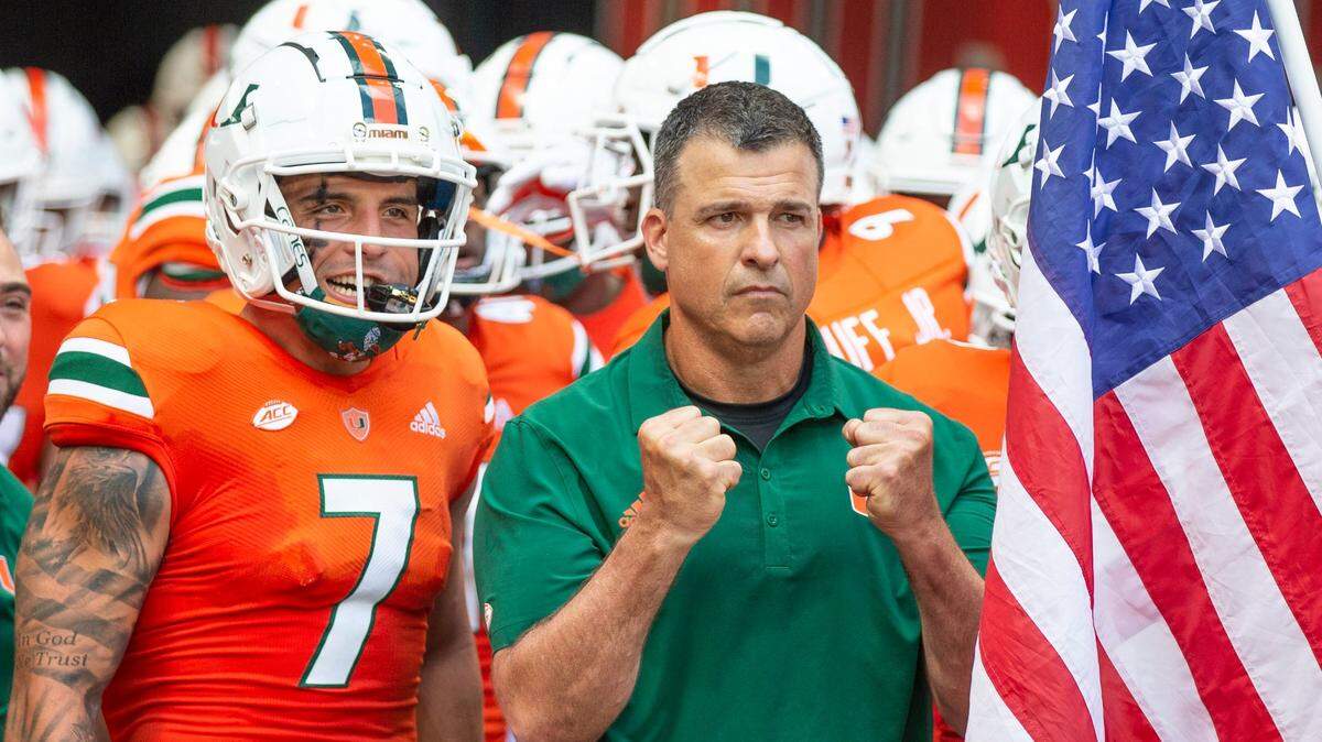 Miami Hurricanes head coach Mario Cristobal and wide receiver Xavier Restrepo (7) prepare to take the field for the start of the game against the Bethune Cookman Wildcats at Hard Rock Stadium in Miami Gardens on Saturday, September 3, 2022.