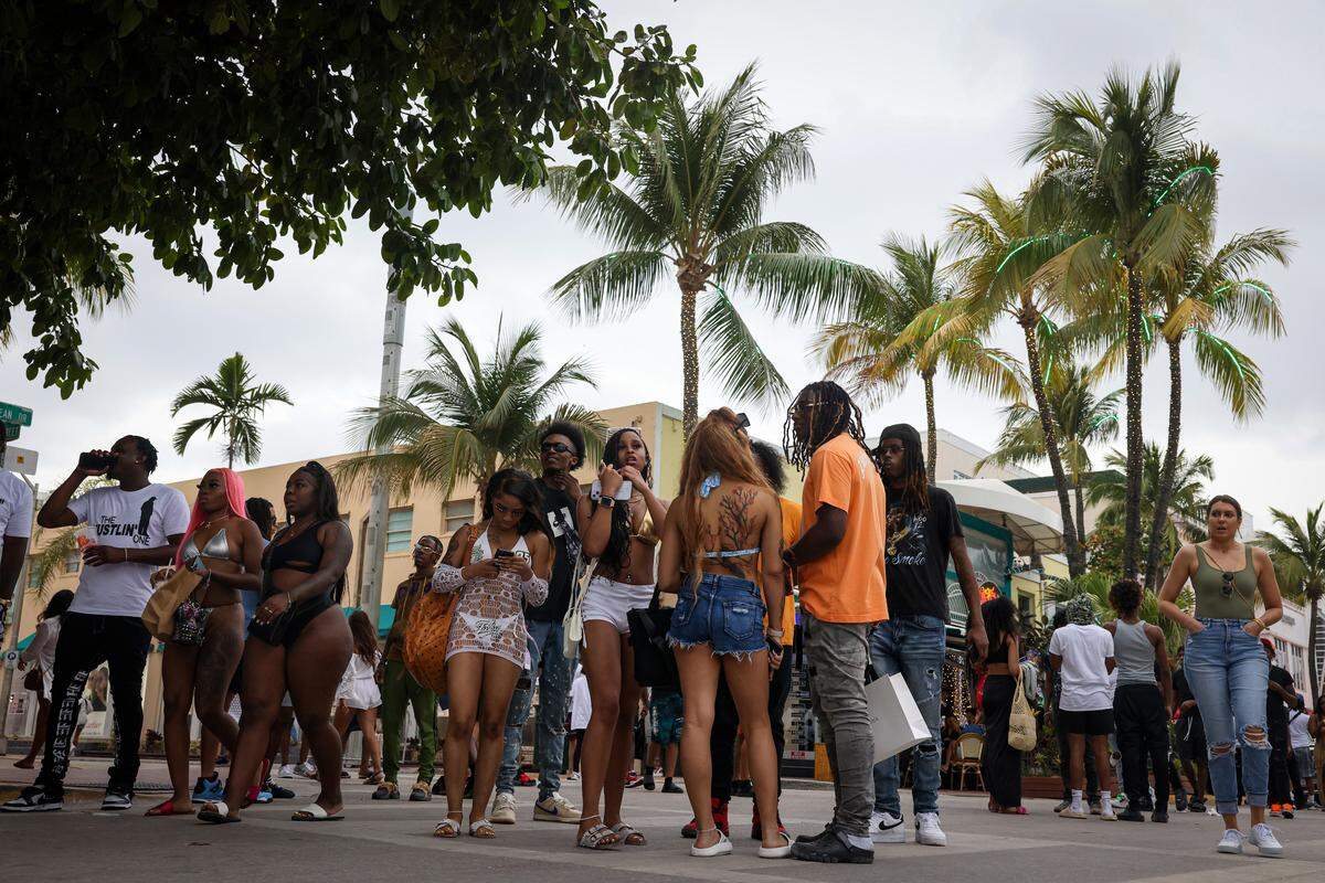 People gather outside of the Waldorf Towers Hotel on Sunday, March 19, 2023, on Ocean Drive in Miami Beach.