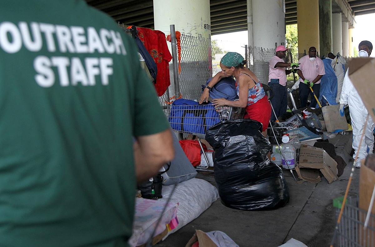 Linda Rios, a homeless woman, packs her belongings on Friday, Oct. 19, 2018, as City of Miami officials and a cleaning brigade swept the streets under the 836/Dolphin Expressway, a place where about 20 homeless people have been living at Northwest 14th Street and First  Avenue in Miami.
