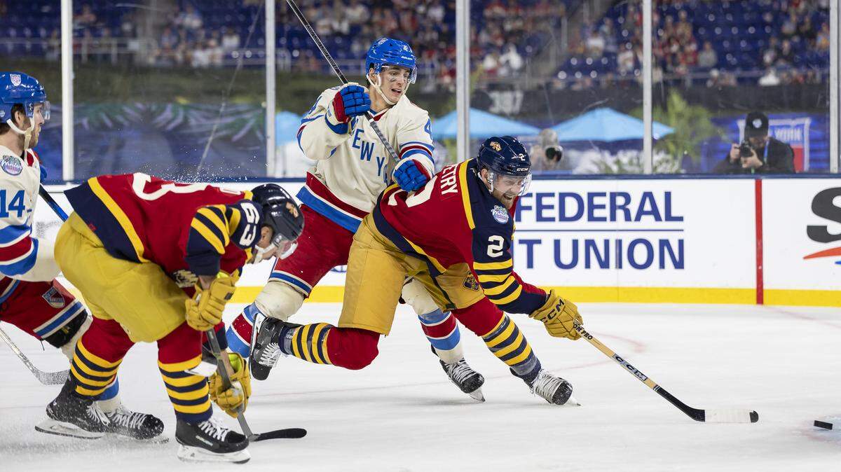 Florida Panthers defenseman Jeff Petry (2) shoots the puck as New York Rangers defenseman Braden Schneider (4) defends in the third period of their Winter Classic outdoor hockey game at loanDepot park on Friday, Jan. 2, 2026, in Miami, Fla.