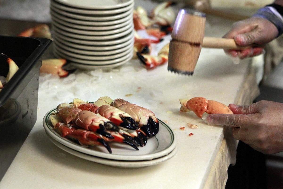 A crab cracker readies fresh stone crabs at Joe’s Stone Crab minutes before the first seating of the season.
