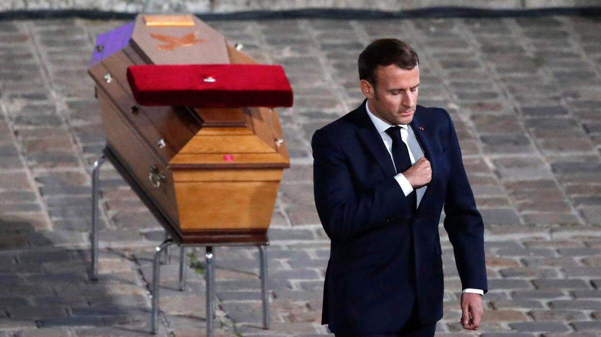 French President Emmanuel Macron leaves after paying his respects to teacher Samuel Paty, who was beheaded in northwest of Paris by a 18-year-old Moscow-born Chechen refugee.
