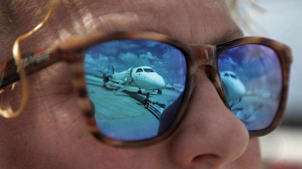 A Silver Airways plane is reflected in the sunglasses of Katie Loughlin, a manager for Silver Airways, on June 28, 2019.