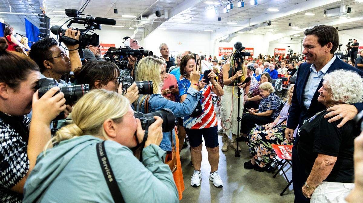 El candidato presidencial republicano, el gobernador de la Florida Ron DeSantis, posa para las fotos con sus partidarios mientras los periodistas documentan la escena durante la recaudación de fondos Ashley's BBQ Bash el domingo 6 de agosto de 2023, en Hawkeye Downs, Cedar Rapids, Iowa.