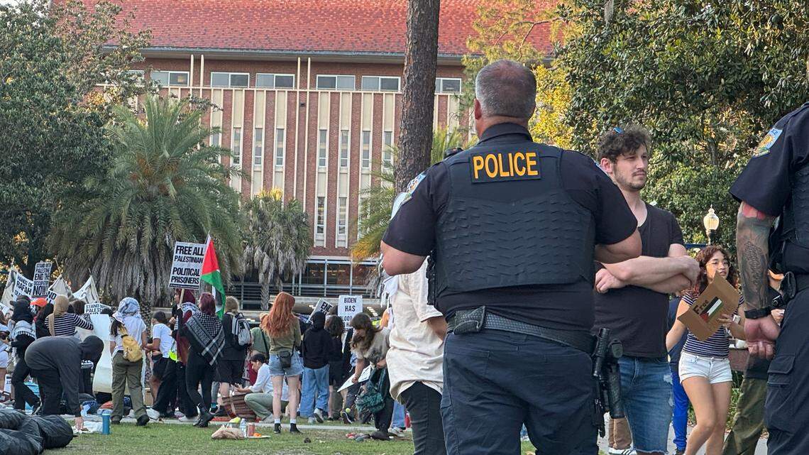 A University of Florida campus police officer watches over about 50 pro-Palestinian protesters who demonstrated on campus Thursday, April 25, 2024, for a second consecutive day. There was no violence or police response – a contrast to what was happening at some other college campuses around the U.S.