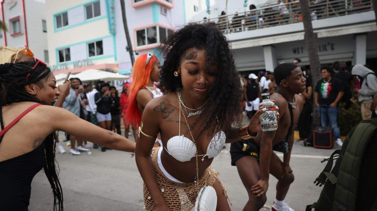 Spring breaker Amya Jackson, center, dances with her friends and Keandre Reese, right, in front of Wet Willies on Sunday, March 19, 2023, on Ocean Drive in Miami Beach.