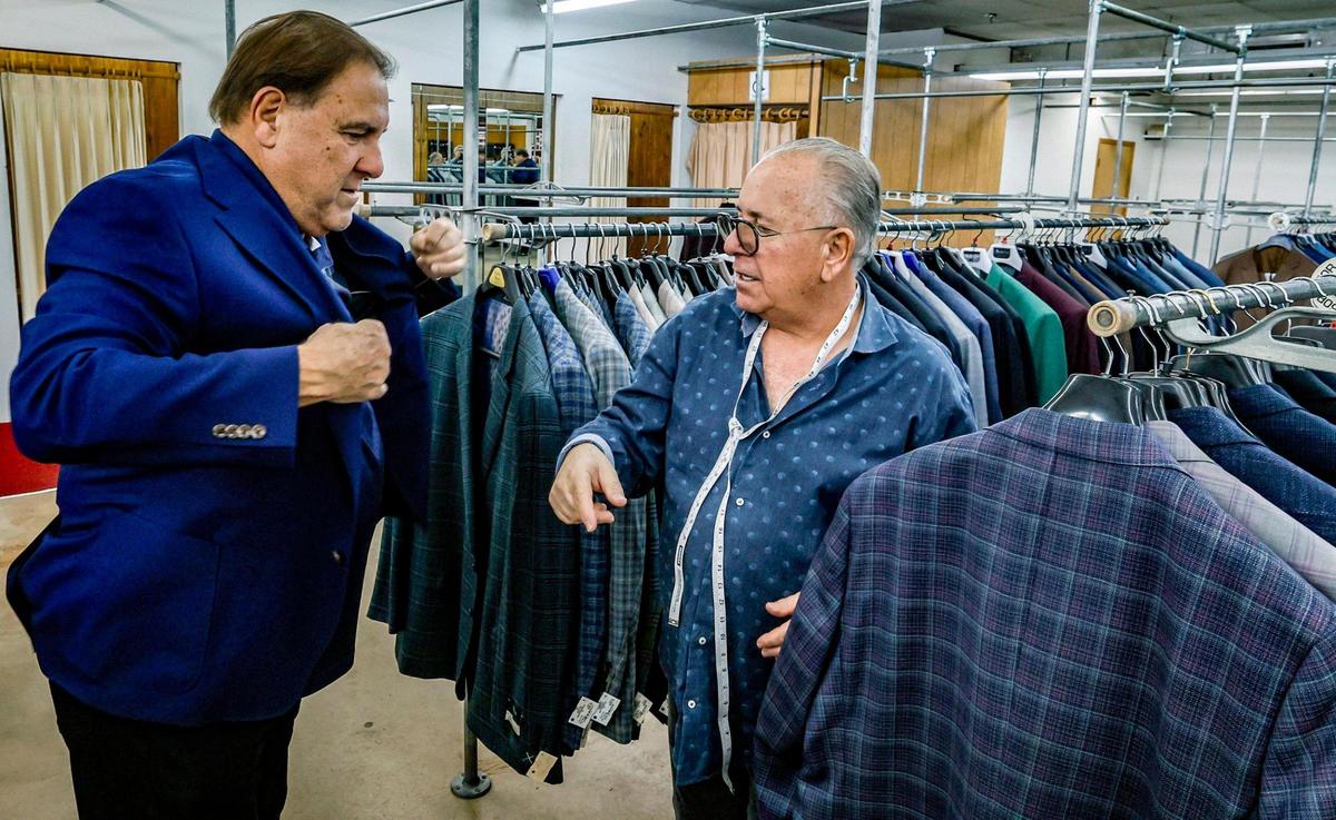 Jose Serra, 71, a 49 year customer of Austin Burke is assisted by Kenny Sager in Miami, Florida on Friday, Jan. 10, 2025. The men’s clothing retail store is hosting retirement sales ahead of its planned March 2025 closing.