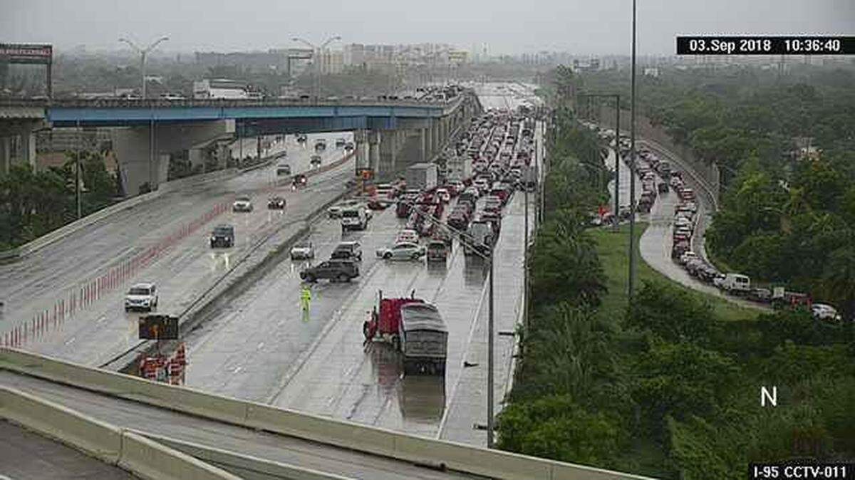 Cars at the back of the traffic jam turn around after a fatal crash shut down Interstate 95 northbound at State Road 112.