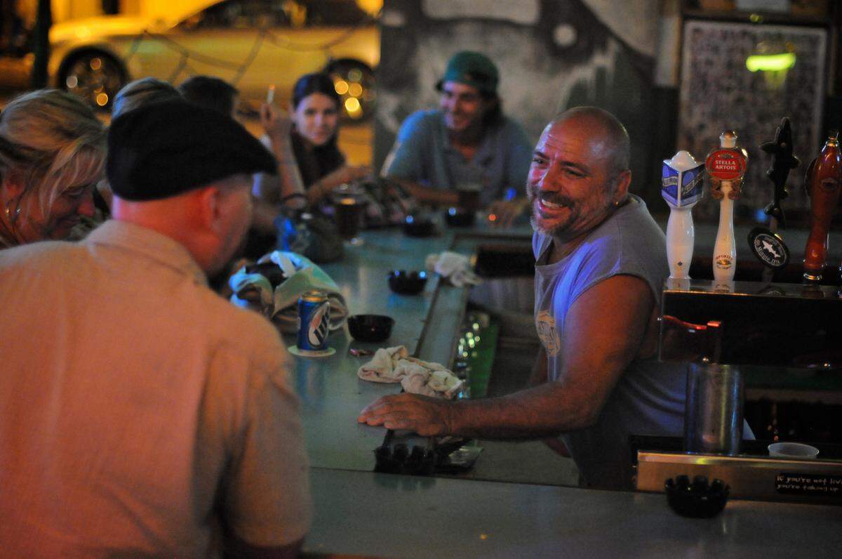 Steve “Beaver” Balmes, a bartender, enjoys a conversation with customers at the Green Parrot Bar in Key West on Friday, July 30, 2010.