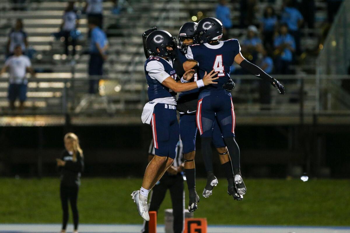 Columbus Explorers wide receiver Fadrelle Andrus, center, celebrates with quarterback Alberto Mendoza, left, and wide receiver Jose Leon (4) after scoring a touchdown during the third quarter of a high school football playoff game against the Palmetto Panthers at Tropical Park in Miami, Florida, Friday, November 18, 2022.