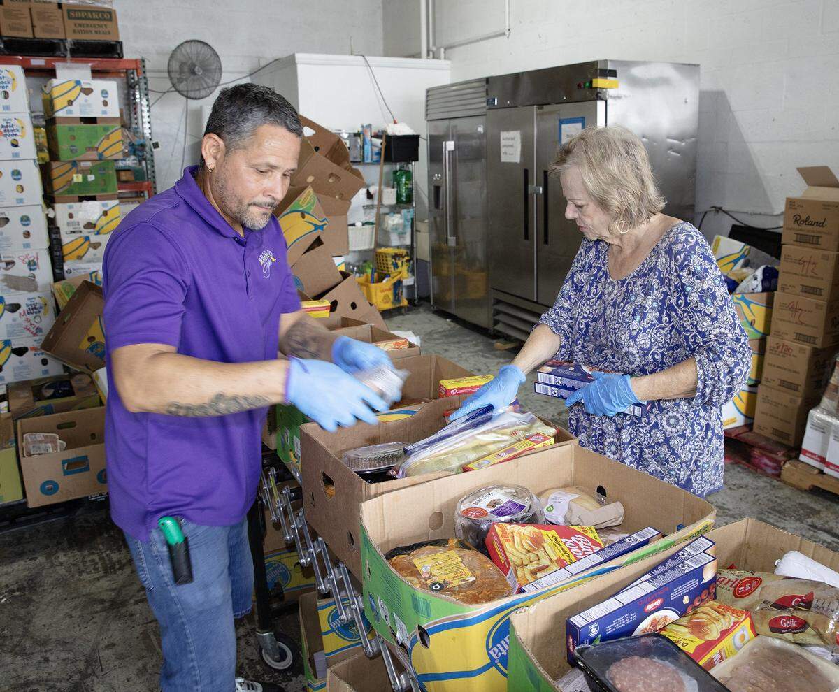 Bridge to Hope volunteers Yeiny Gonzalez and Barbara Franklin prepare boxes of healthy food for people in need on Thursday, September 18, 2025 in Cutler Bay. Andrew Uloza / for Miami Herald