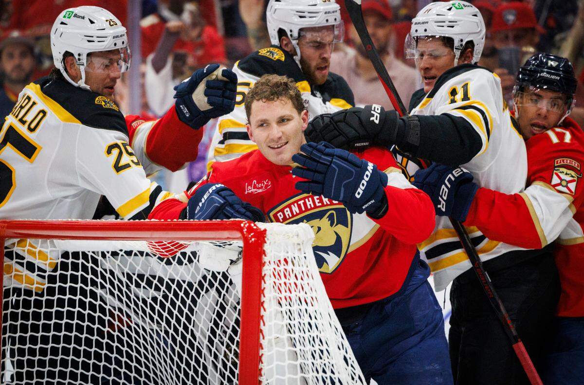 Florida Panthers left wing Matthew Tkachuk (19) smiles after saying something while Bruins players hit him during the third period of home opener of the Florida Panthers against the Boston Bruins on Tuesday, Oct. 8, 2024, at Amerant Bank Arena in Sunrise, Fla. The Florida Panthers won 6-4.