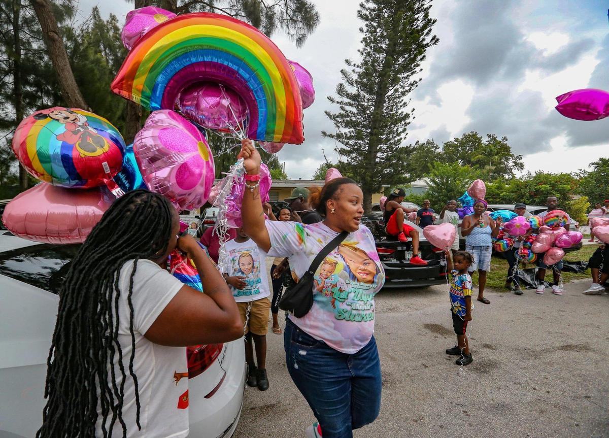 Devera Stukes, at center, holds a balloon release and fish fry to help raise money to pay for her daughter’s funeral seven months after a tragic hit-and-run that killed her daughter Laziyah Stukes, 10, and two other girls and left several children injured. Family and friends gathered at the Fort Lauderdale home on Saturday, July 16, 2022.