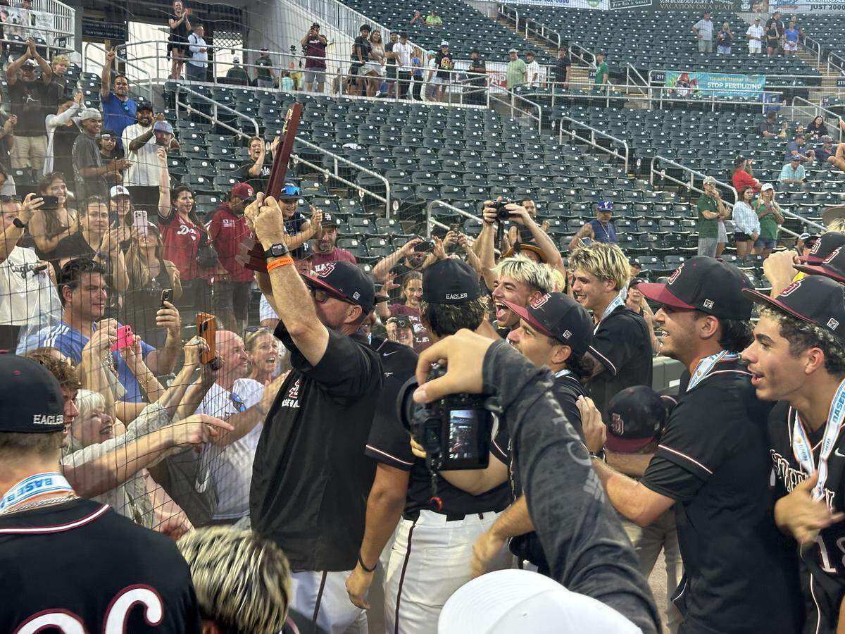 Stoneman Douglas coach Todd Fitz-Gerald holds up the state championship trophy on Saturday after beating Venice 2-1 on Saturday night to win the Class 7A state championship at Hammond Stadium in Fort Myers, Fla.