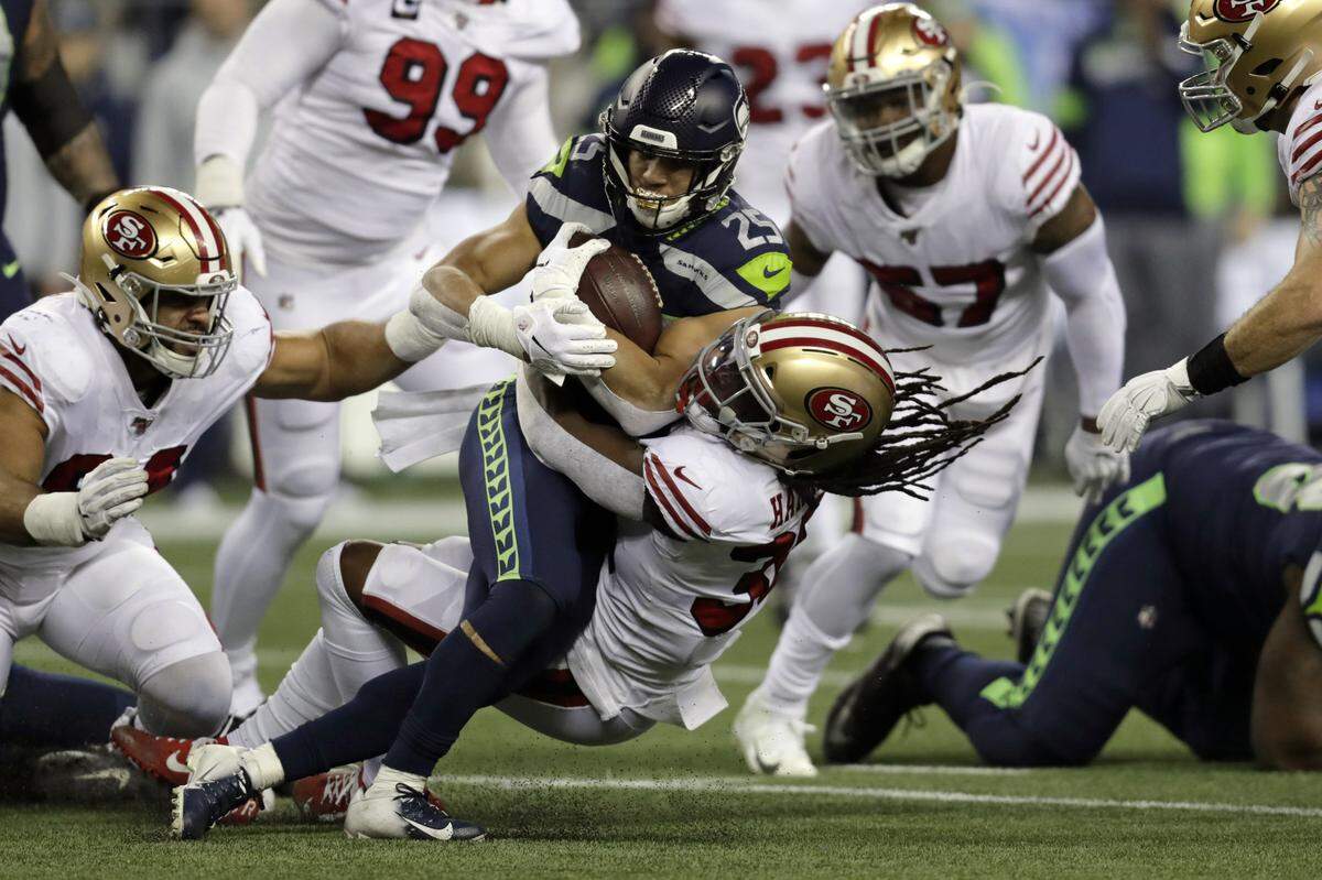 Seattle Seahawks running back Travis Homer (25) is brought down by San Francisco 49ers’ Marcell Harris on a carry during the first half of an NFL football game, Sunday, Dec. 29, 2019, in Seattle. (AP Photo/Stephen Brashear)